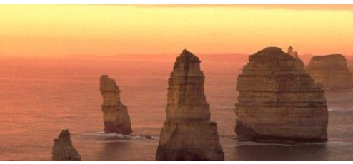 large rock stacks in water at sunset